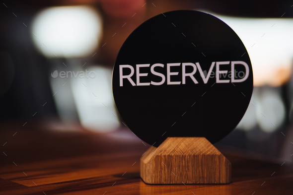 Reservation card on festive table shows occupied place by customers