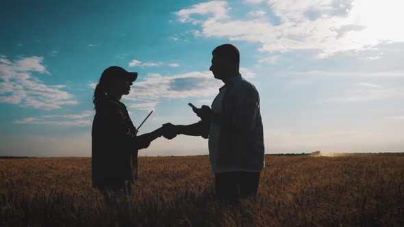 Farmers Handshake Over the Wheat Crop in Harvest Time. Team Farmers Stand in a Wheat Field with alt