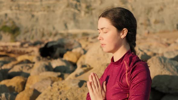 Stressed woman meditates with her palms folded in a namaste gesture and breathing deeply alt