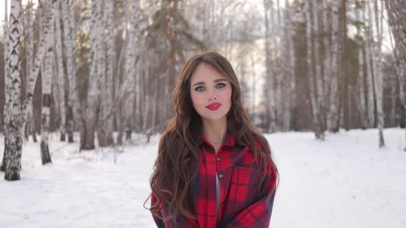 Charming Female with Long Hair Walking in Snowy Forest