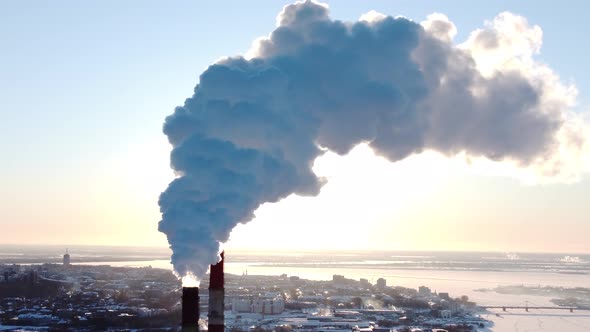 Chimneys of a Factory or Power Plant Produce Smoke at Sunrise Aerial View From a Drone