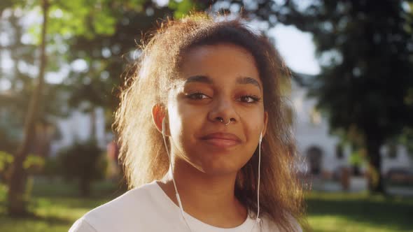 Portrait of Young Attractive African American Woman Smiling in City Street Wearing Headphones alt