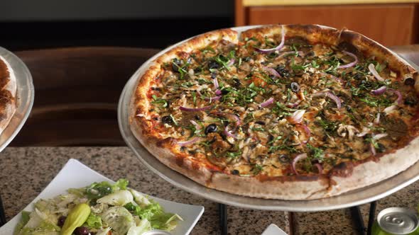 A trio of large thin crust pizzas set up for a party buffet, slider 4K alt