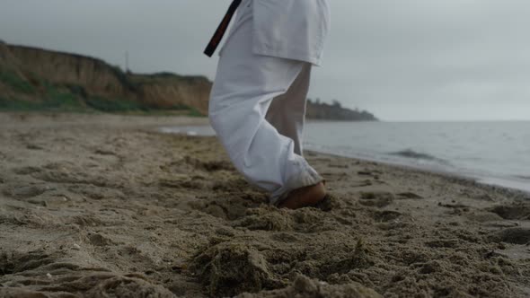 Man Feets Stepping on Beach Sand Practicing Karate Overcast Weather Close Up alt
