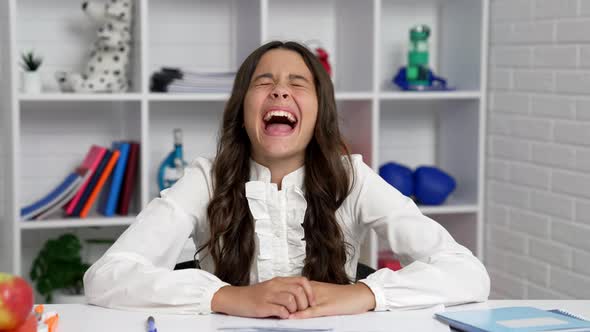 Expressing Child Portrait Laughing at Funny Joke in Classroom Having Fun