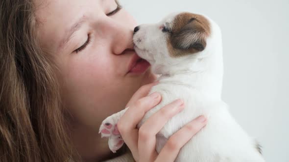 Girl Petting and Playing with a Small Puppy alt