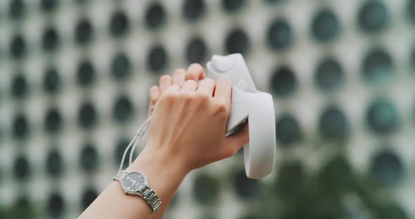 Close up of female hands using vr controllers alt