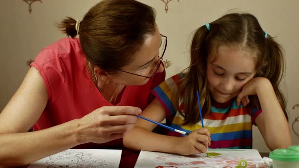 A Grown Woman Teaches a Little Girl the Art of Drawing