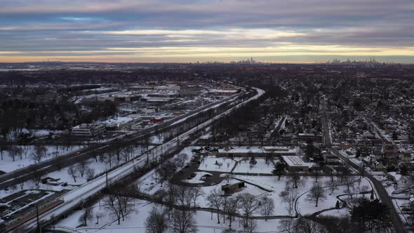An aerial shot of a suburban park at sunrise. It was at after a snow storm and taken near train trac alt
