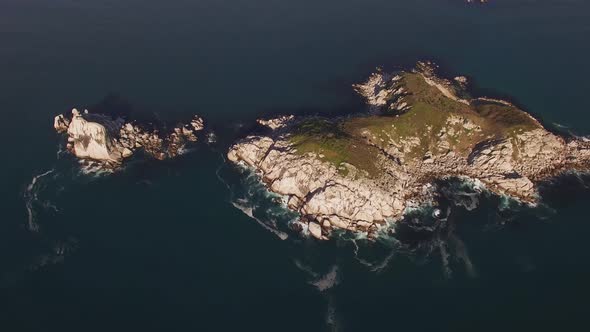 Aerial View of a Beautiful Small Rocky Island Surrounded By Clear Blue Sea alt