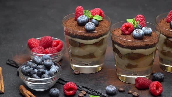 Classic Tiramisu Dessert with Blueberries and Raspberries in a Glass on Stone Serving Board alt