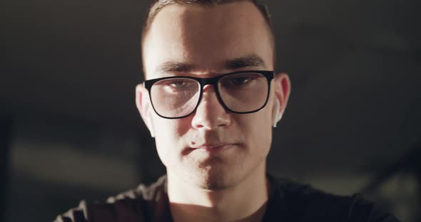 Portrait of Man with Glasses During Work on an Exercise Bike in a Gym alt