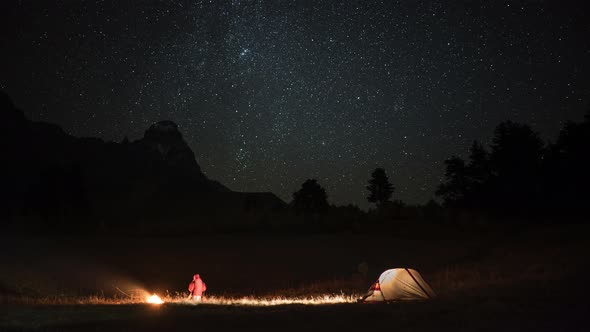 Time Lapse of Camping with a Man, Tent and Campfire at Night alt