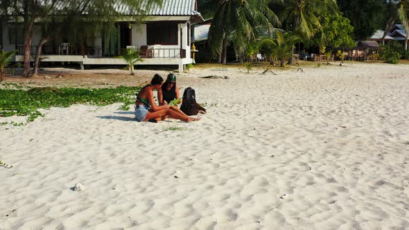 Beautiful fun women on holiday enjoying life at the beach on summer white sandy and blue 4K backgrou alt