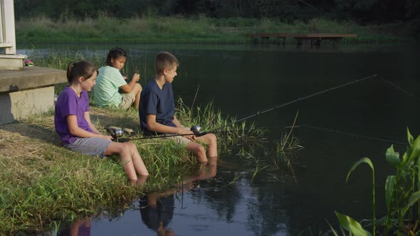 Kids at summer camp fishing in pond
