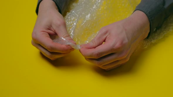 Human Hands Popping the Bubbles in Bubble Wrap alt
