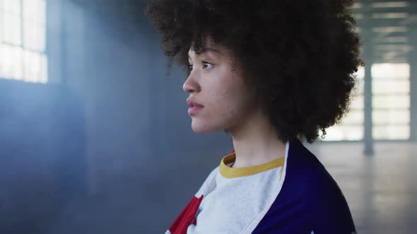 Portrait of african american woman with american flag on her back in empty parking garage alt
