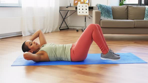 African Woman Making Abdominal Exercises at Home alt