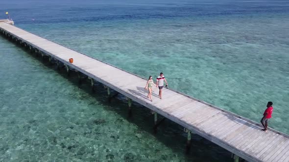 A Man and a Woman Couple Walking on Wooden Decking Bridge Holding Hands