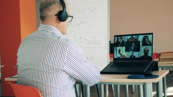 A Man Is Demonstrating a Book To Students During Online Class. Online Learning, Online Education alt