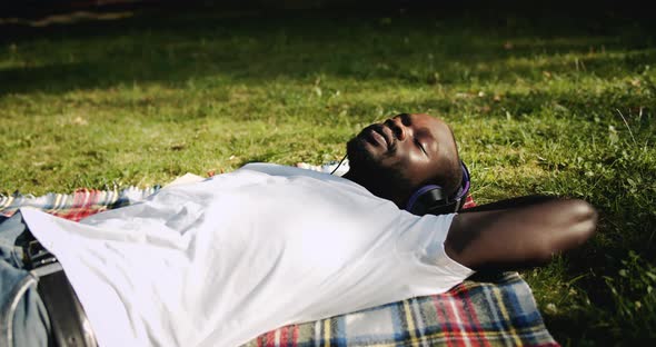 Afro-american Man Enjoying Music in Park