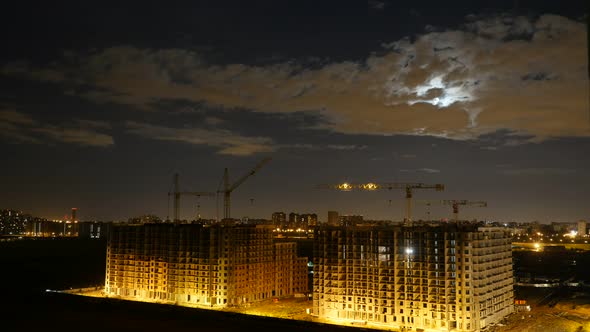 Clouds Moving Across the Sky Over the Construction of Building. Night City View