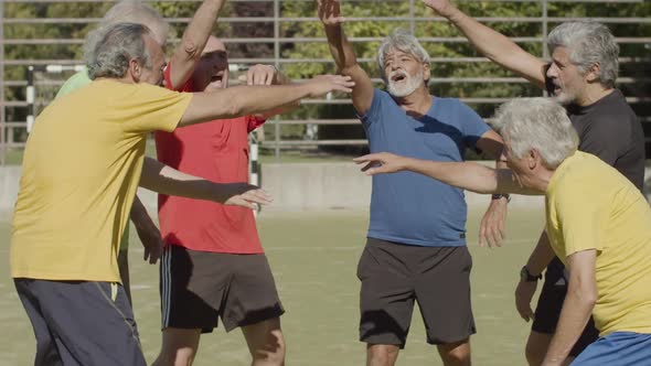Senior Sportsmen Standing Outside and Putting Hands Together alt