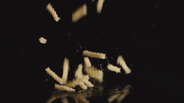 Сurly pasta falls into water