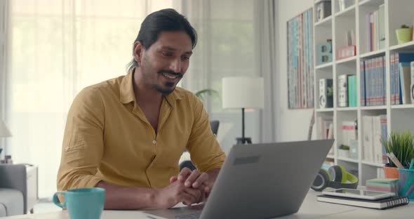 Man sitting at desk at home and video calling