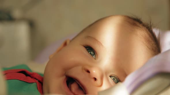 Portrait of a Happy Baby Lying in a Cradle and Smiling Closeup. alt