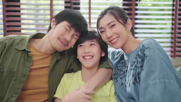 Portrait of Asian sweet family  sitting and smiling in living room  son hug his parent with love
