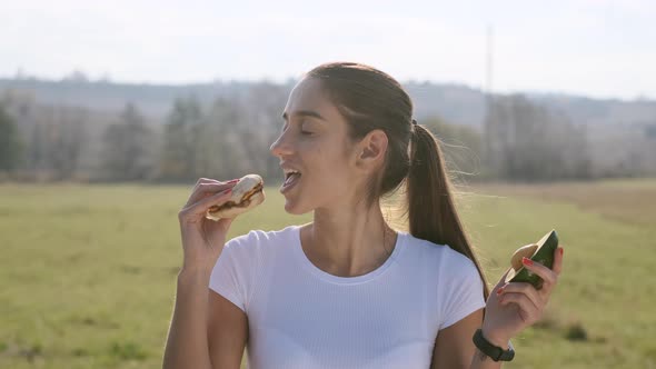 Girl Trying To Choose Between Hamburger And Avocado alt