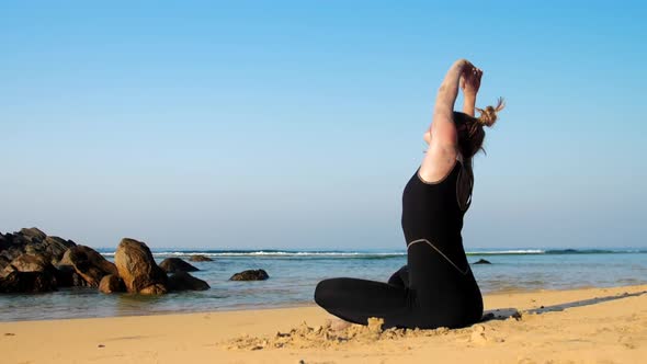 Lady Stretches Back Practicing Yoga Exercises Against Ocean alt