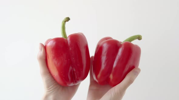 Private Farmer Shows Ripe Red Peppers on a White Background