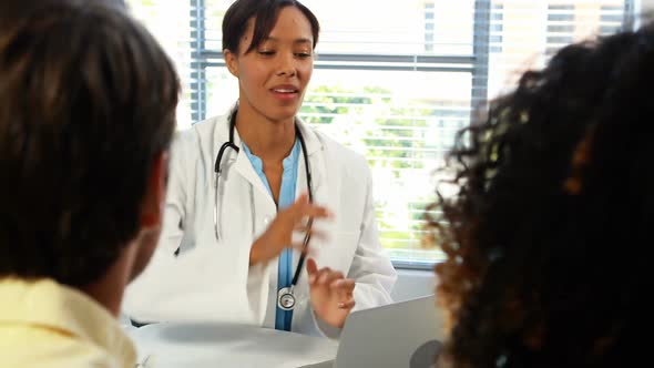 Couple talking to doctor in clinic alt