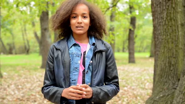 Young Lively African Girl Talk About Herself in the Forest - Make Gestures with Hands - Eye Contact alt