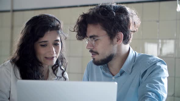 Front View of Focused Young Woman Talking with Confident Colleague alt