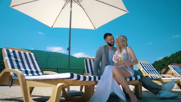 Man and girl at a resort in a hotel under a beach umbrella alt