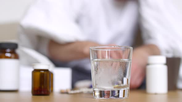 Unrecognizable Sick Man Throwing Tablet in Water alt