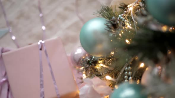 Christmas Gifts in Boxes of Blue and Pink Lie Next the Decorated Christmas Tree at Home alt