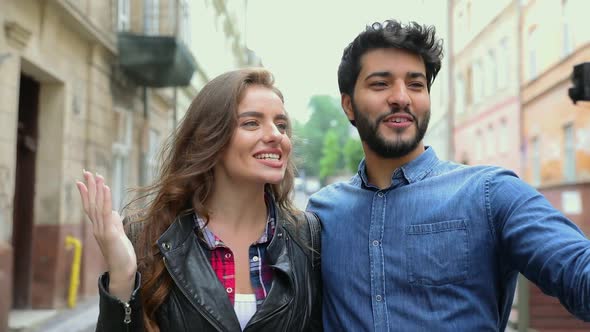 Video blogging. Couple recording vlog on camera at city street alt