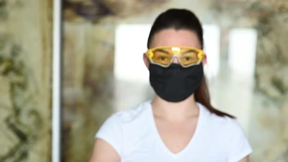 A Girl in a Protective Mask Glasses and Gloves Spray an Antiseptic To Prevent Infection alt