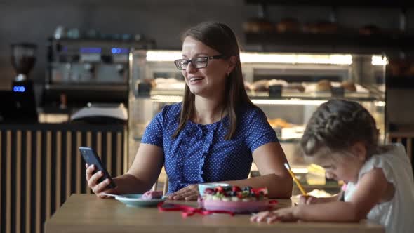 woman makes a video call via a phone in a cafe alt
