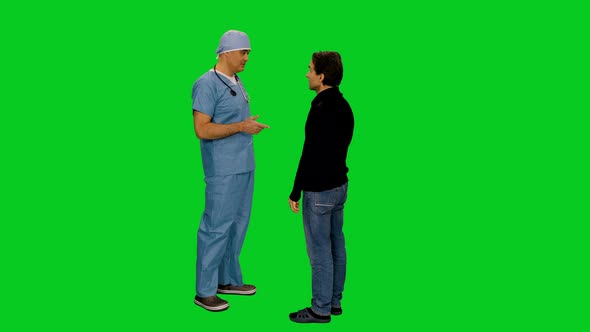 Surgeon In Uniform Talking To Patient While Standing In Hallway Of Hospital