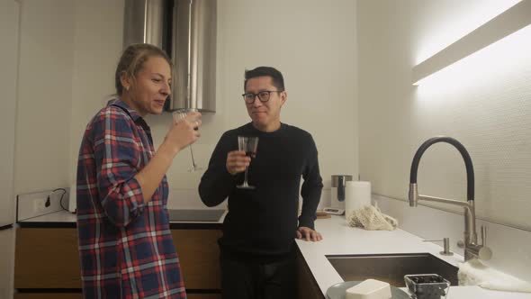Man and woman cooking together and drinks wine