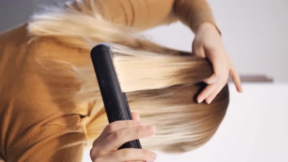 Vertical Video Woman Straightens Her Hair alt