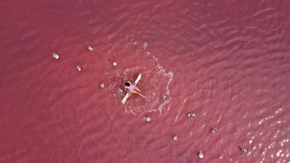 Woman Is Sunbathing in a Striped Bathing Suit alt