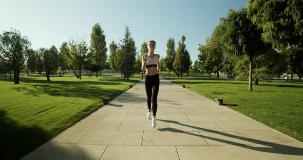 Young Caucasian Woman is Running in the Park