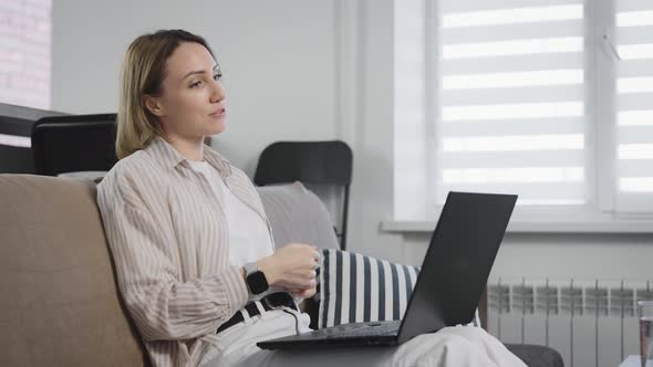 An Attractive and Emotional Woman Communicates with Loved Ones Via the Internet alt