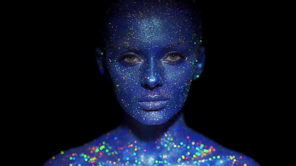 Portrait of Beautiful Woman with Blue Sparkles on Her Face